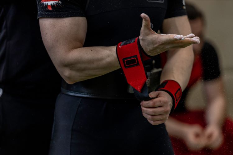 Close-up of a man putting on lifting straps