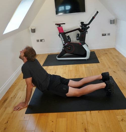 Man in home gym performing yoga poses