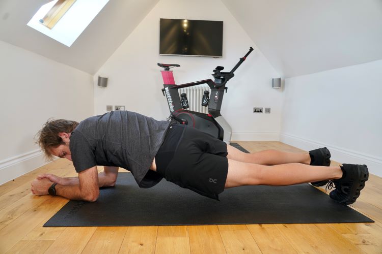 Man in home gym performing plank variations