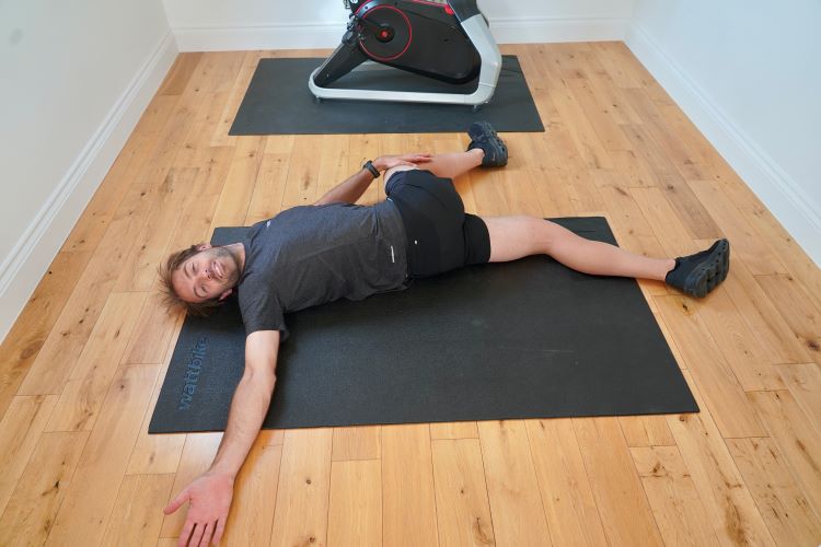 Man performing spinal twist on home gym floor