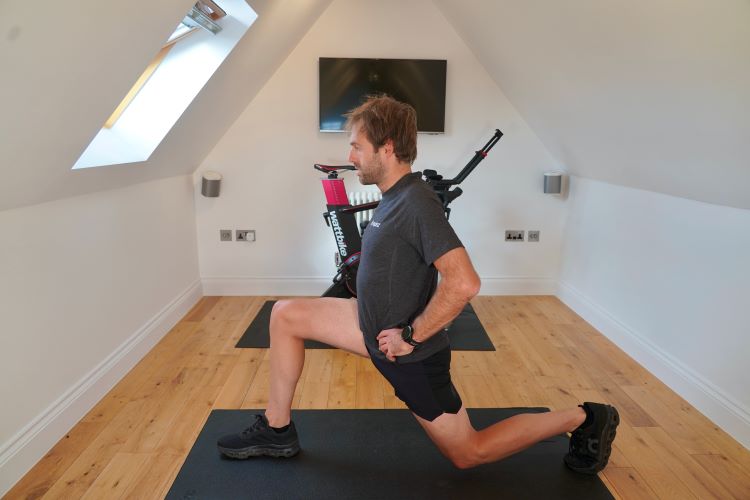 Man in home gym performing a split squat
