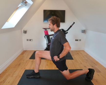 Man in home gym performing a split squat