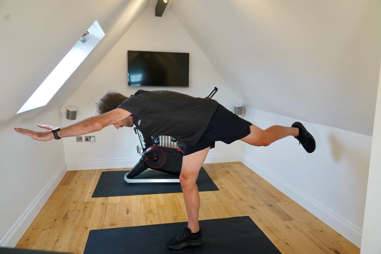 Man performing stretches in home gym, including the best strength exercises for cyclists