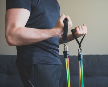Close up of a man holding resistance band handles