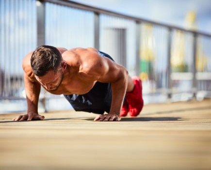 Portrait of a athletic man doing push-ups outside