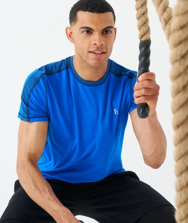 Man in gym shirt exercising with battle ropes