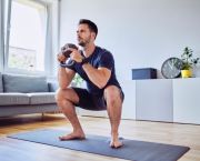 Man at home performing goblet squats