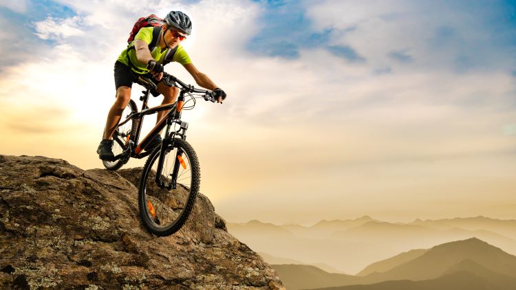 Mountain biker riding down rocky path