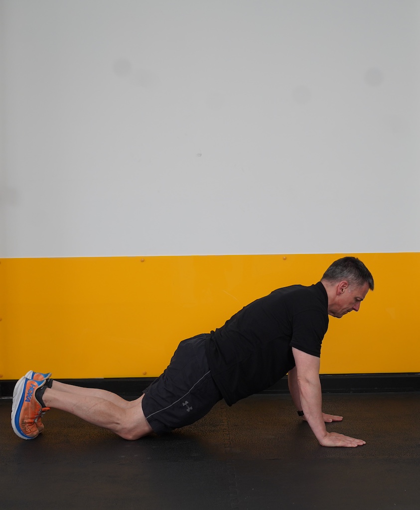 man performing push up on knees to show how to strength train in your sixties