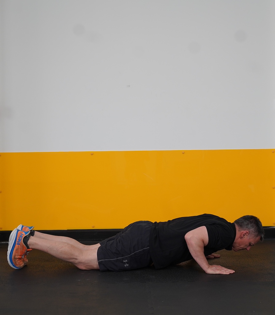 man performing push up on knees to show how to strength train in your sixties
