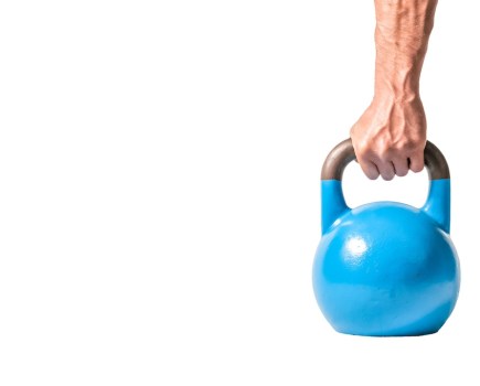Strong muscular man hand with muscles holding blue heavy kettlebell partially isolated on white background