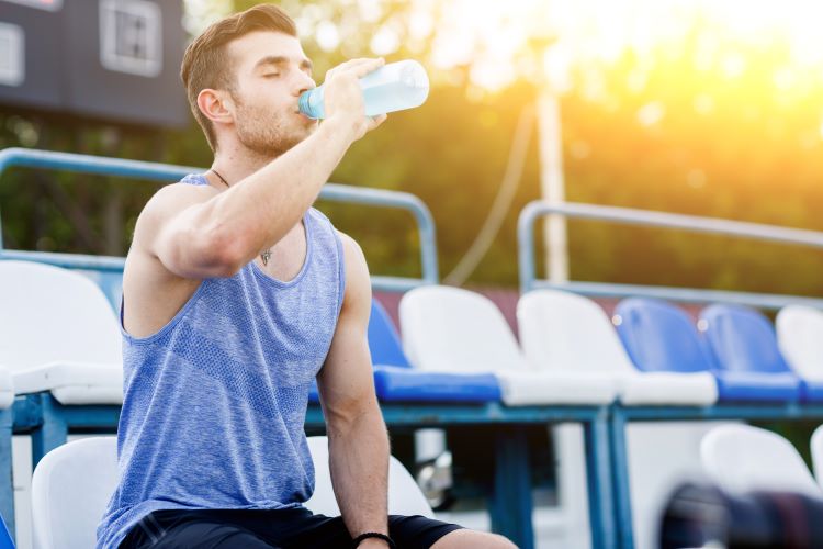 A male athlete drinking an electrolyte drink