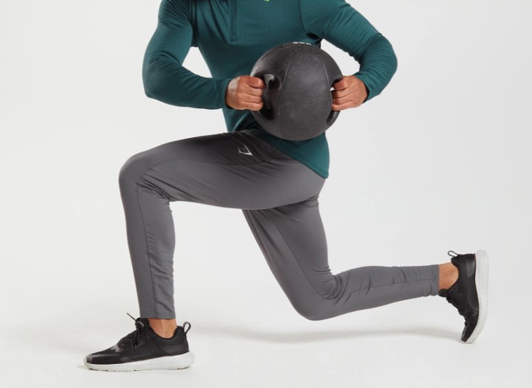 Shot of lower torso of a man wearing joggers exercising with a medicine ball