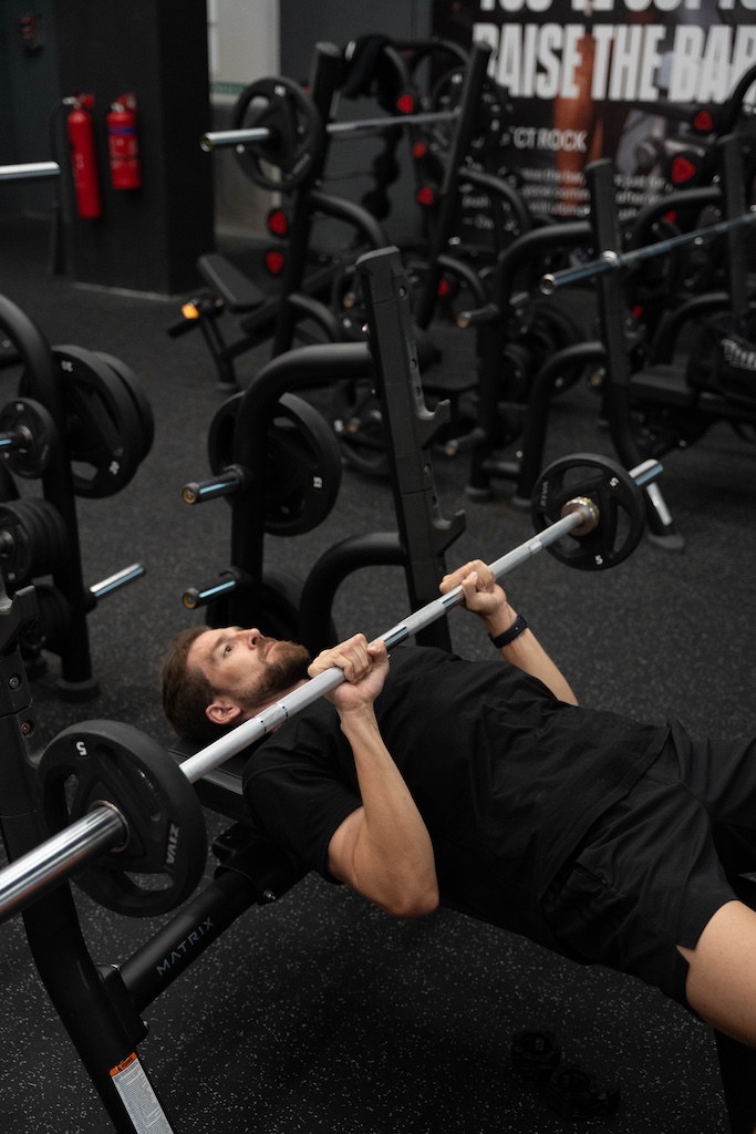 PT demonstrating how to perform a close-grip bench press in a workout routine for beginners