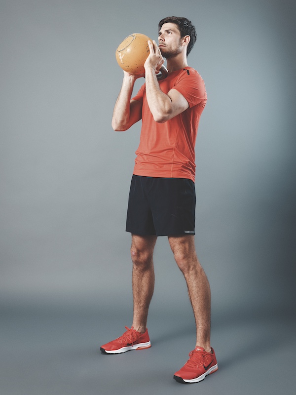 man in fitness kit demonstrating how to do a goblet squat as part of a beginners kettlebell workout