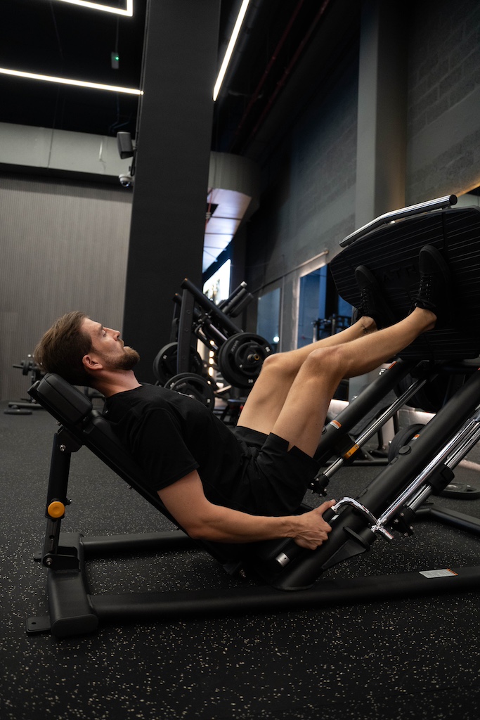 PT demonstrating how to perform a leg press