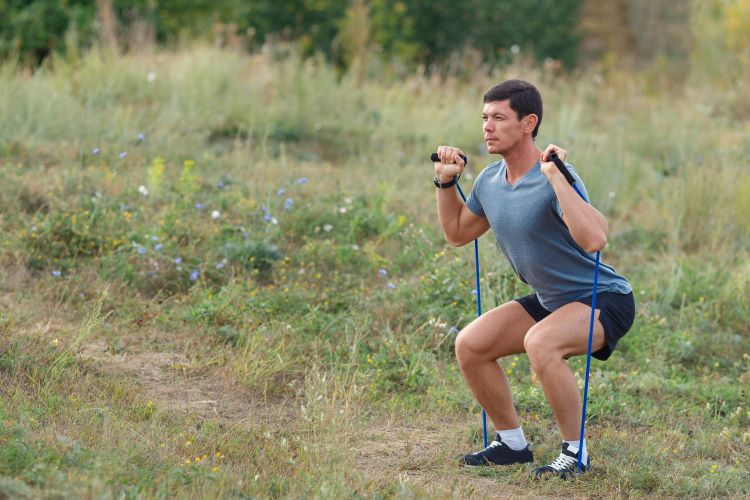 Man doing resistance band workout outside
