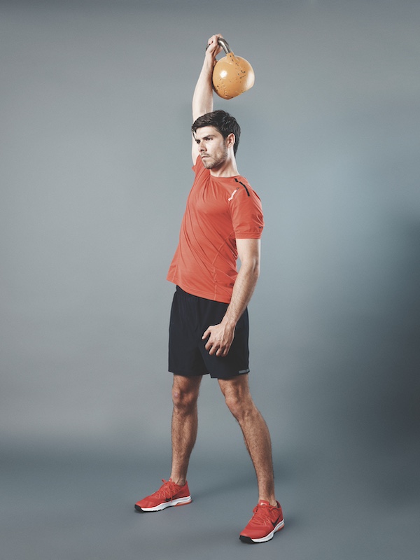 man in fitness kit demonstrating how to do a single-arm kettlebell press as part of a beginners kettlebell workout