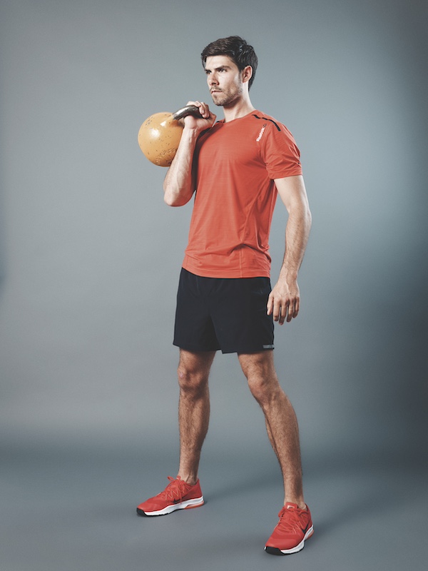man in fitness kit demonstrating how to do a single-arm kettlebell press as part of a beginners kettlebell workout