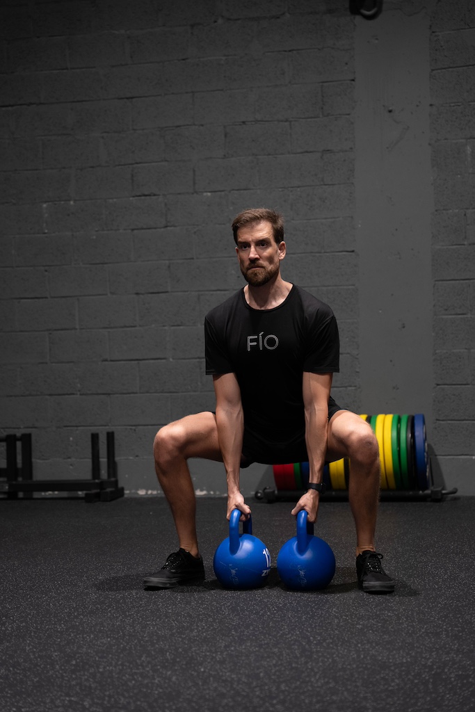 PT demonstrating how to perform a kettlebell sumo squat