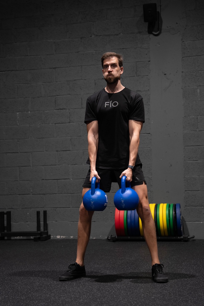 PT demonstrating how to perform a kettlebell sumo squat