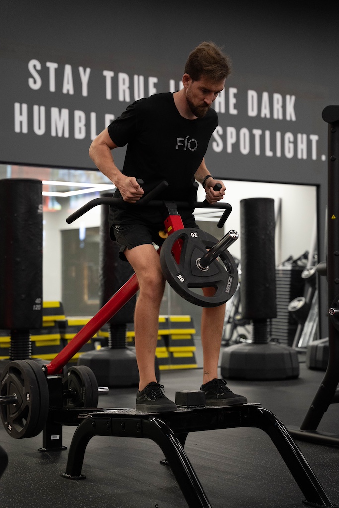 PT demonstrating how to perform a T-Bar row in a workout routine for beginners