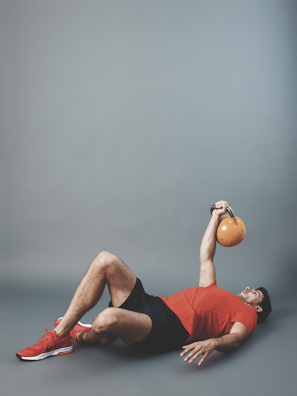 fitness model demonstrating how to do the kettlebell Turkish get-up as part of a kettlebell workout