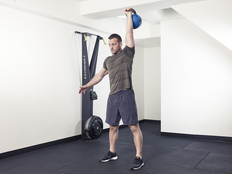 fitness model demonstrating how to perform a kettlebell windmill