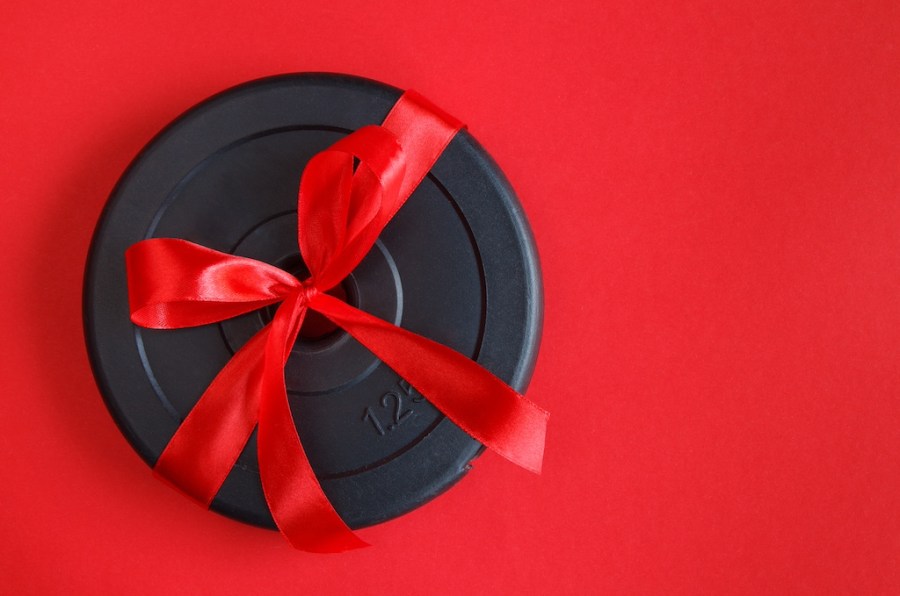Weight plate wrapped in red ribbon as part of Men's Fitness' New Year Gift Guide