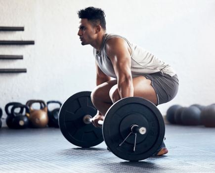 man in gym performing deadlift as part of a New Year Workout Plan