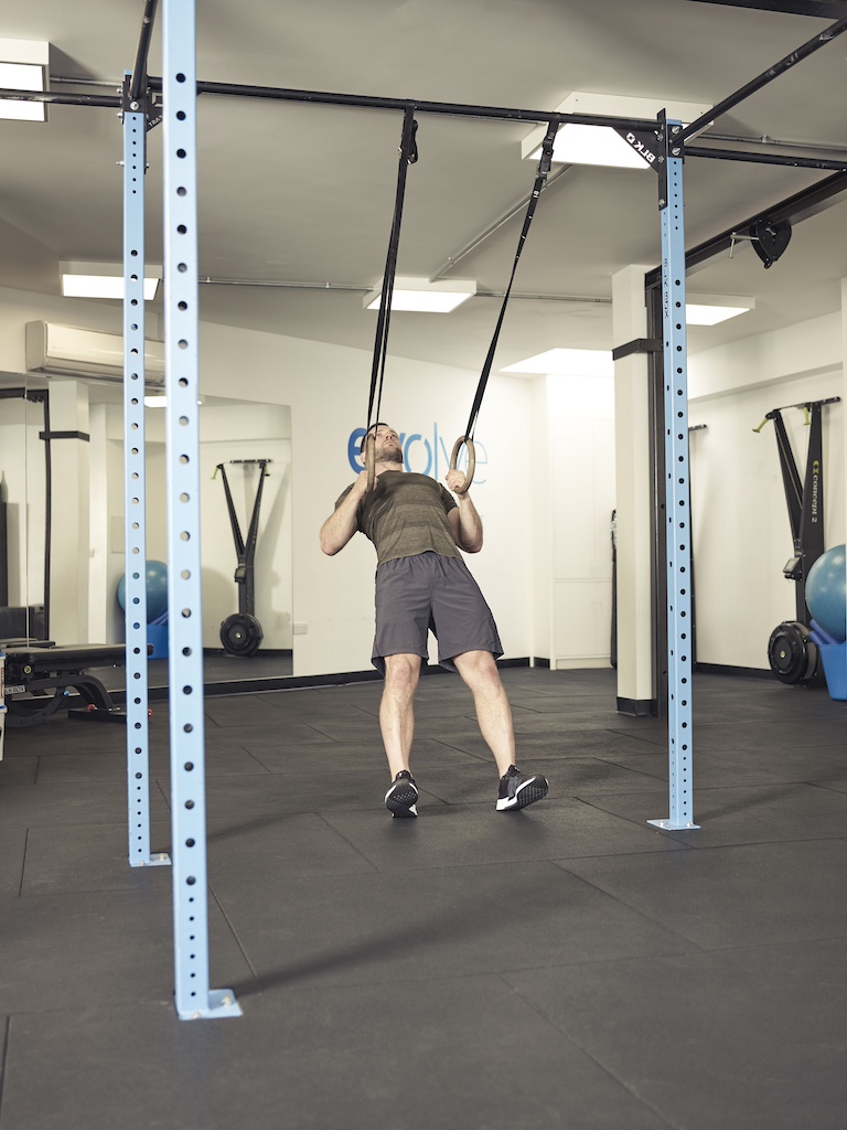 man performing an inverted row suspension trainer abs exercise