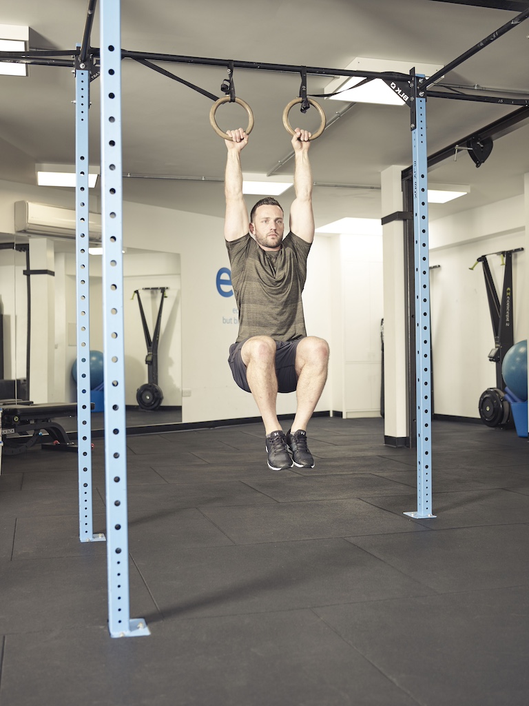 man performing a knee raise suspension trainer abs exercise