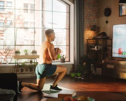 Man at home working out in front of TV