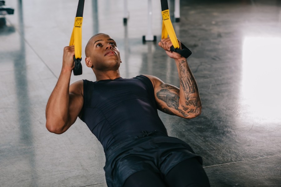 man doing inverted row suspension trainer abs exercise