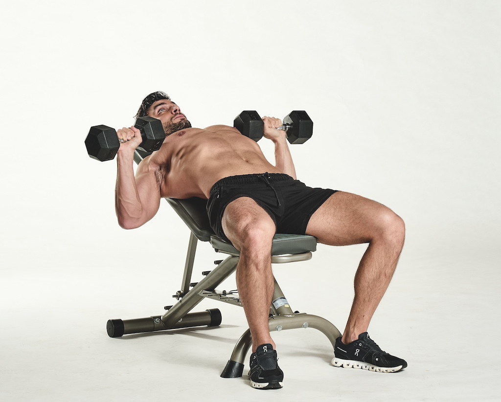 man performing incline dumbbell bench press as part of the busy man's training plan