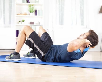 Man exercising on a mat at home