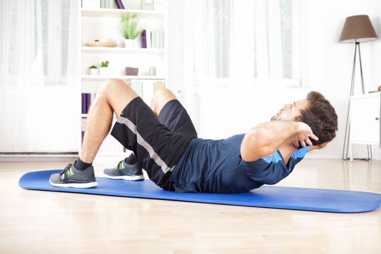 Man exercising on a mat at home