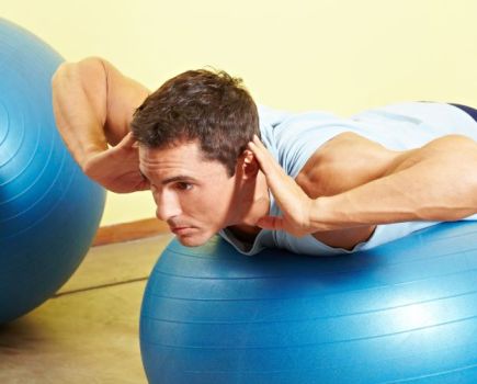 Man performing bodyweight exercises on an exercise ball