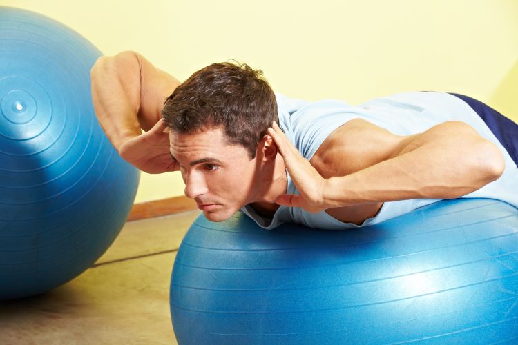 Man performing bodyweight exercises on an exercise ball