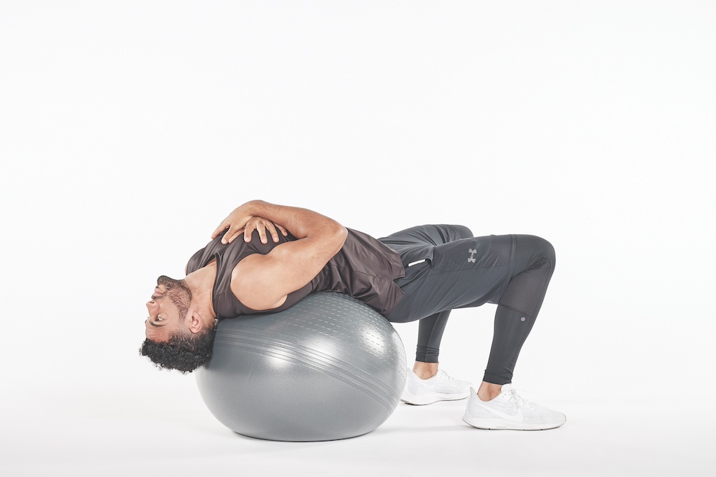 man performing exercise ball crunch exercise