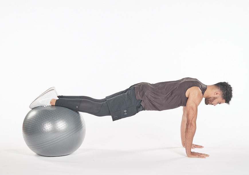 man performing exercise ball pike exercise