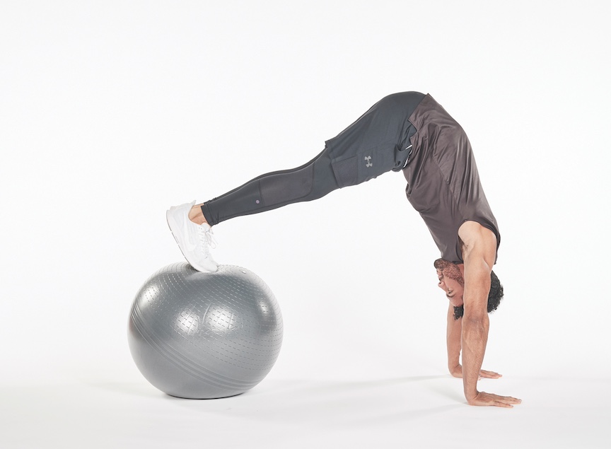 man performing exercise ball pike exercise