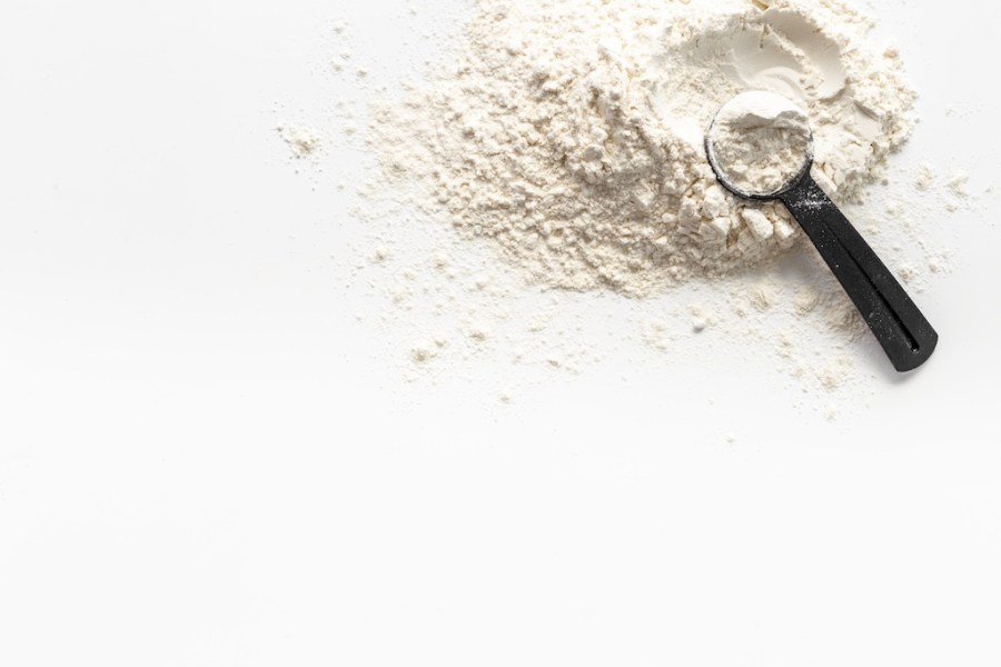 white protein powder with black scoop to show how much protein you should have with each meal