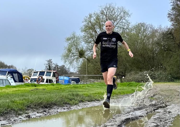 Man running through muddy puddles