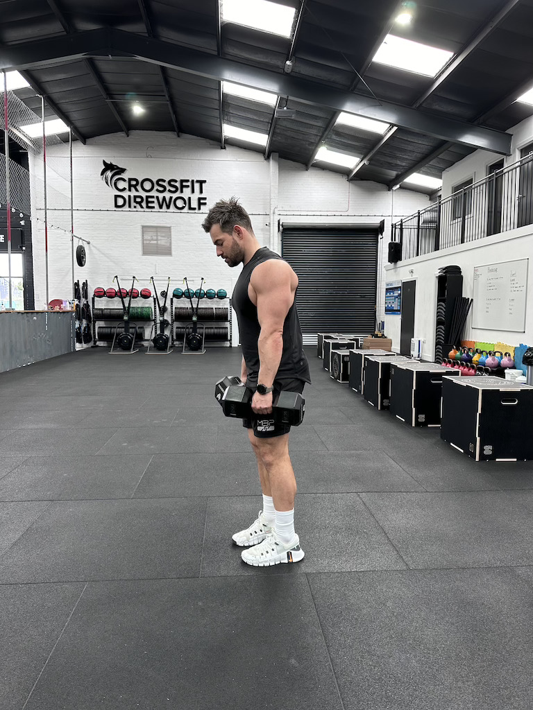 PT demonstrating how to do a dumbbell romanian deadlift as part of a dumbbell-only leg workout