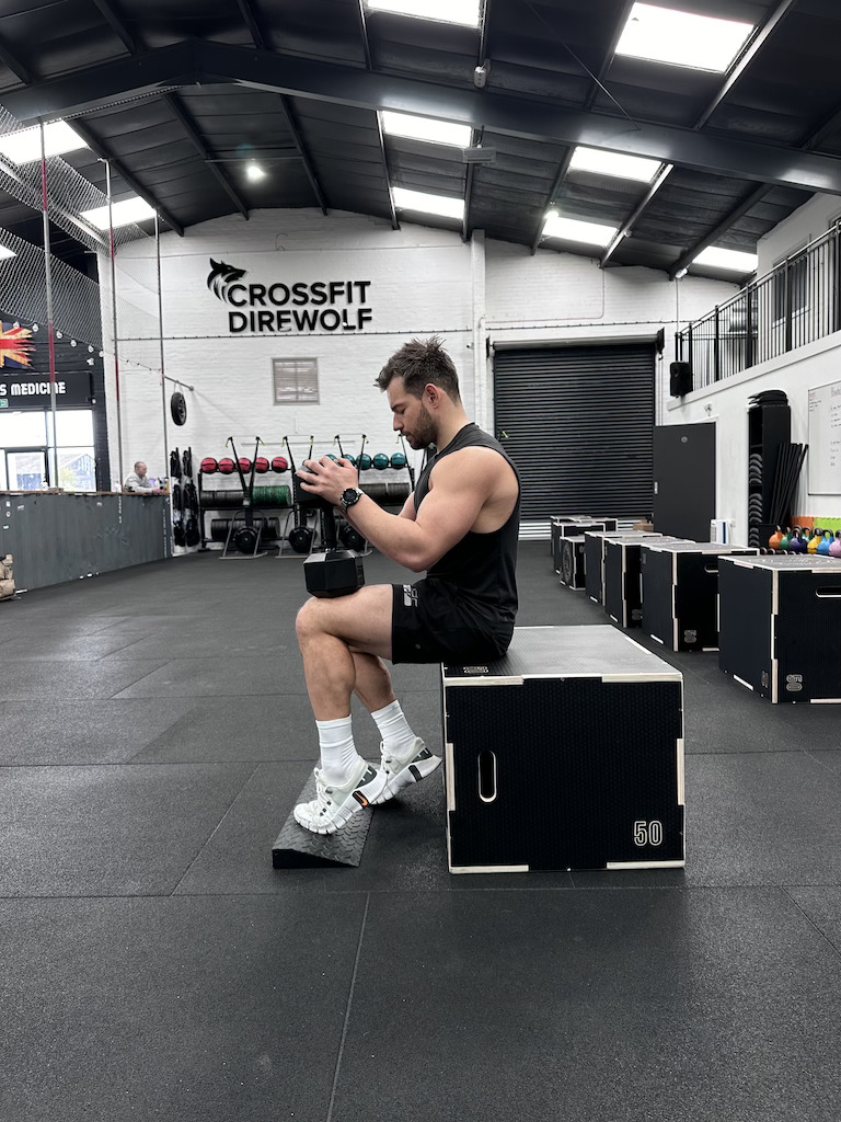PT showing how to do a dumbbell bent-knee calf raise