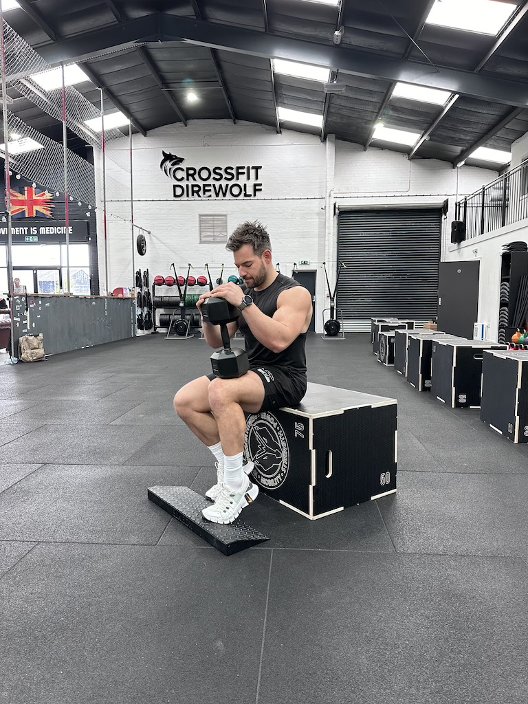 PT showing how to do a dumbbell bent-knee calf raise