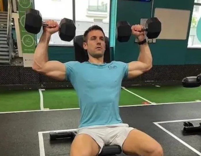 Close-up of man in a gym performing a shoulder press