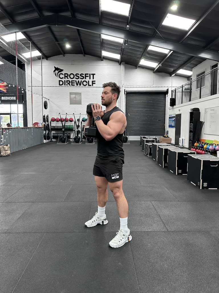 man performing dumbbell goblet squat as part of a dumbbell-only leg workout