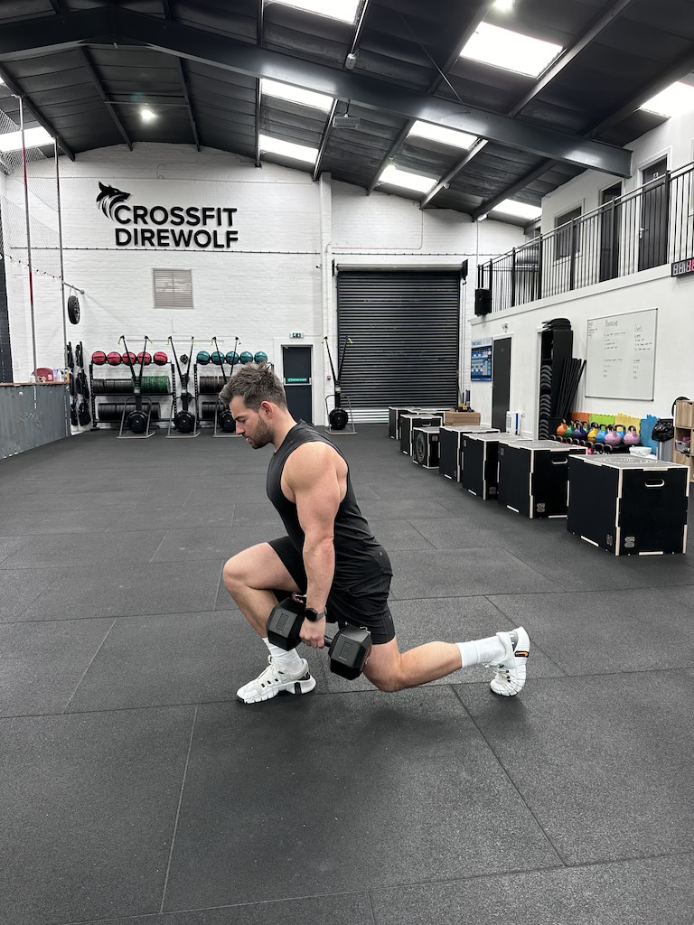 PT demonstrating how to do a dumbbell walking lunge